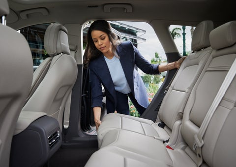 A woman slides the second-row seat forward to create more cargo space | Klaben Lincoln of Warren in Warren OH