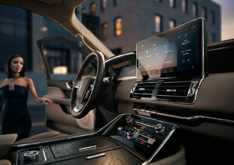 The 13.2-inch LCD touchscreen dominates the front cabin as a woman gets in the driver's door | Klaben Lincoln of Warren in Warren OH