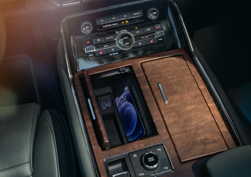 A smartphone is charging on the wireless charging pad in the front center console cubby | Klaben Lincoln of Warren in Warren OH
