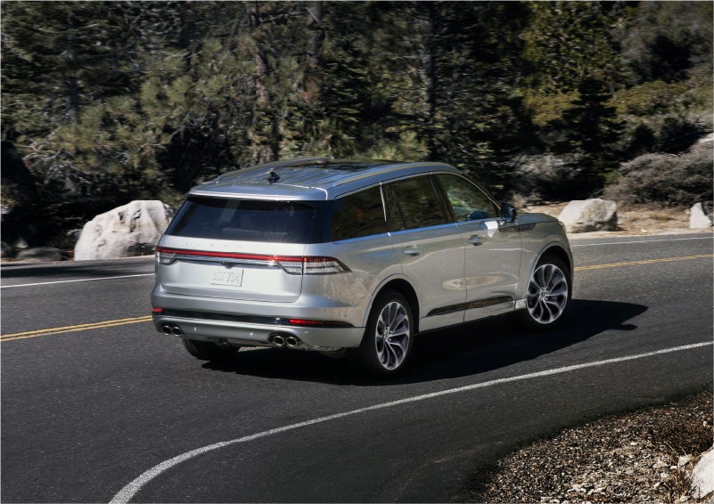 A 2023 Lincoln Aviator® Grand Touring model is shown being driven on a tight turn of a mountain road | Klaben Lincoln of Warren in Warren OH