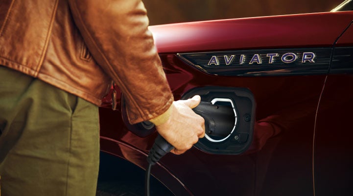 A hand is shown plugging in the charger into the charging port of a 2021 Lincoln Aviator | Klaben Lincoln of Warren in Warren OH