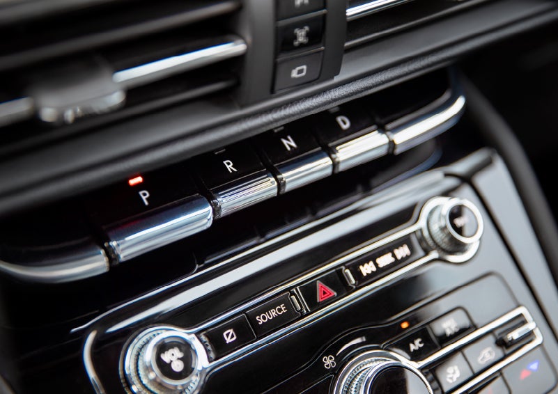 The Park button on the elegant Piano Key Shifter is lit up and engaged as light dances off the chrome accents and horizontal design lines | Klaben Lincoln of Warren in Warren OH