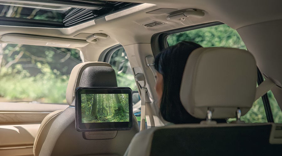 A woman sitting in the second row is viewing a nature scene on the Lincoln Play screen