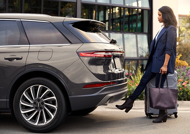 A woman with her hands full uses her foot to activate the available hands-free liftgate. | Klaben Lincoln of Warren in Warren OH
