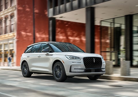 The 2024 Lincoln Corsair® SUV with the Jet Appearance Package and a Pristine White exterior is parked on a city street. | Klaben Lincoln of Warren in Warren OH