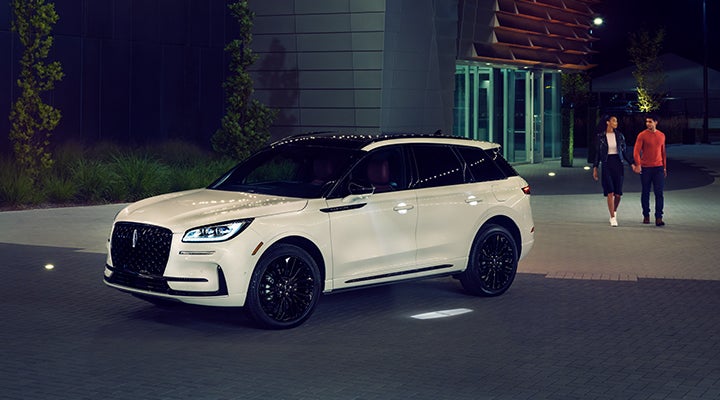 Two people approach a 2024 Lincoln Corsair® SUV featuring the available Jet Appearance Package. | Klaben Lincoln of Warren in Warren OH