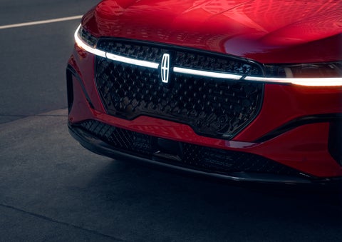 The available front LED light bar and center Lincoln Star logo glow at dusk. | Klaben Lincoln of Warren in Warren OH