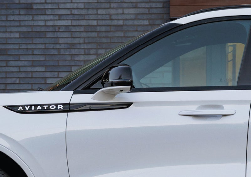 The driver’s side door and fender badging of a white 2026 Lincoln Aviator® SUV are showcased. | Klaben Lincoln of Warren in Warren OH