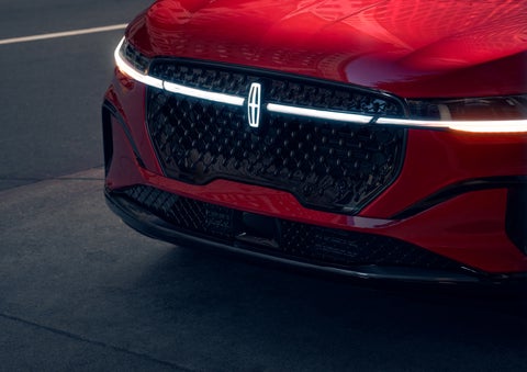 The available front LED light bar and center Lincoln Star logo glow at dusk. | Klaben Lincoln of Warren in Warren OH