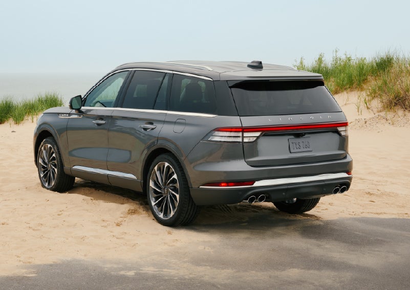 A 2027 Lincoln Aviator® SUV is parked next to sand dunes. | Klaben Lincoln of Warren in Warren OH