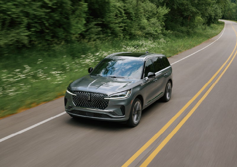 A 2027 Lincoln Aviator® SUV is being driven down a road. | Klaben Lincoln of Warren in Warren OH