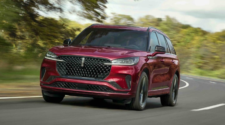 A 2027 Lincoln Aviator® SUV is being driven on a country road | Klaben Lincoln of Warren in Warren OH