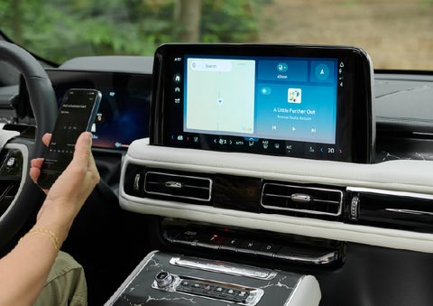 A person pairs thier phone with the center touchscreen of a 2027 Lincoln Aviator® Black Label™ SUV | Klaben Lincoln of Warren in Warren OH